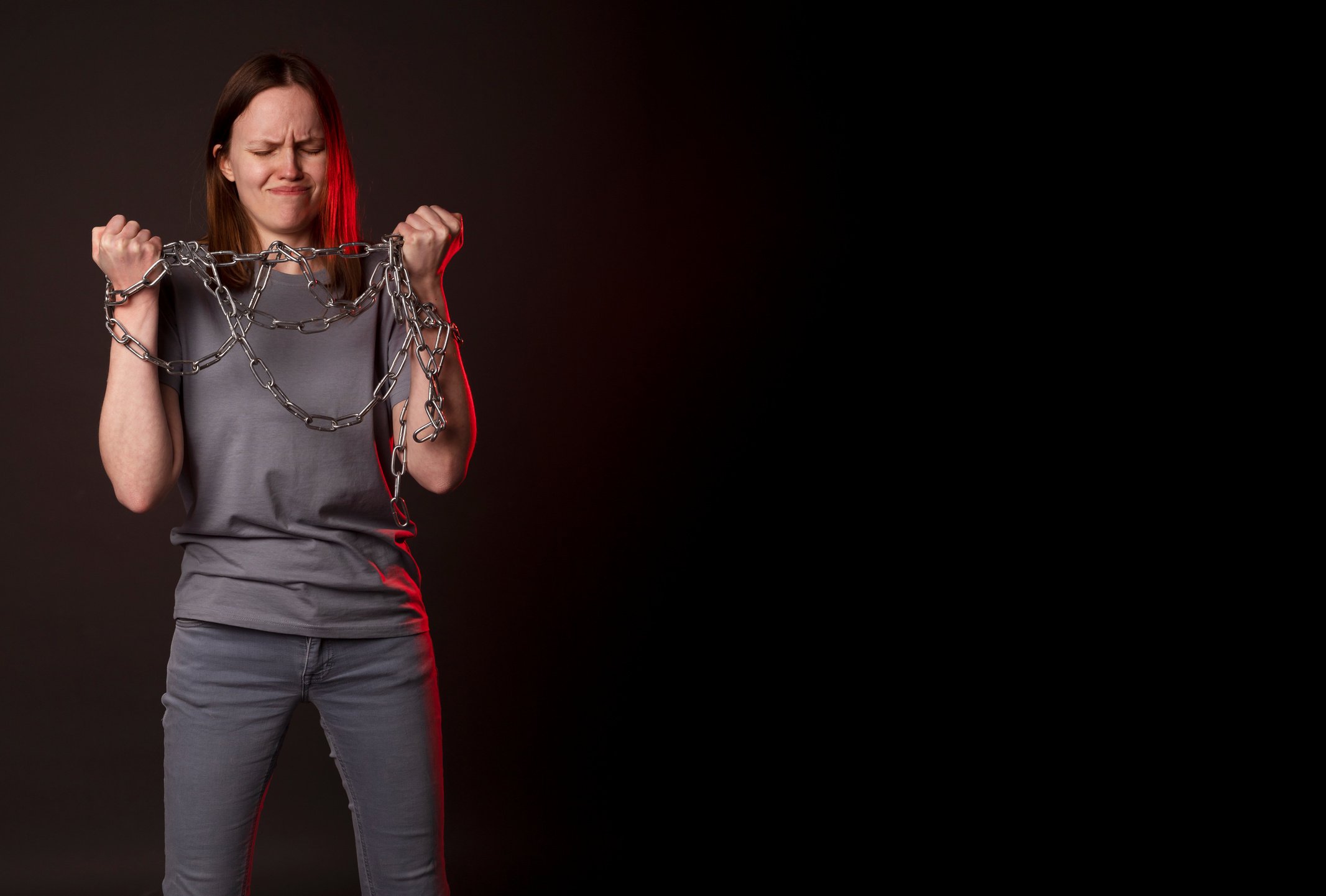 Woman Breaking Chains on Black Background Copy Space